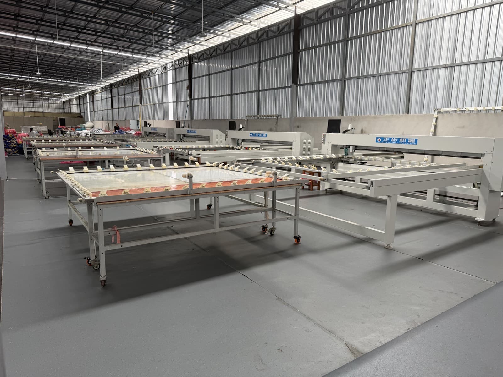 Rows of modern quilting machines in the production hall